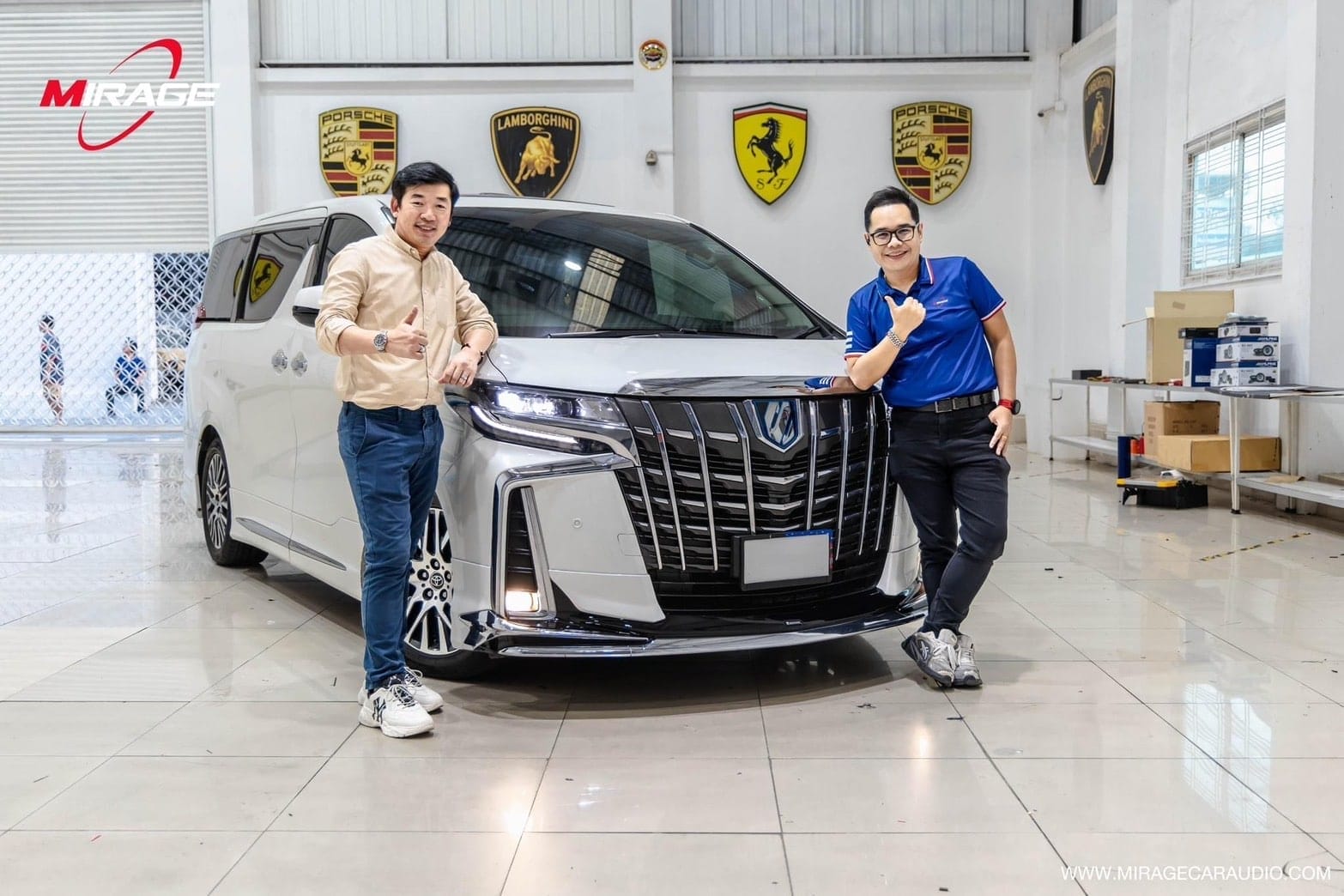 กล้องติดรถยนต์ งาน MIRAGE EXPRO Motor Show 2024: ชายสองคนยืนข้างรถตู้สีขาว, โลโก้ Porsche, Lamborghini, Ferrari